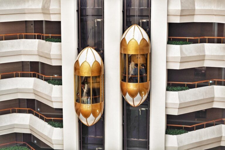 People in a Golden Elevator Passing Another